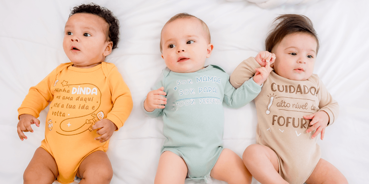 Três bebês usando bodies bordados coloridos da coleção Korte Rekorte